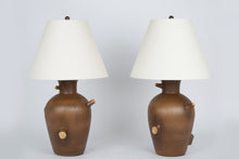 Pair of Faux Bois lamps with no bases in natural matte brown glaze with oil rubbed brass double socket clusters and off white vellum paper shades, on a white background.