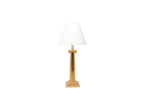 Ionic candlestick lamp in gold luster glaze with an off white vellum paper lampshade, on a white background.