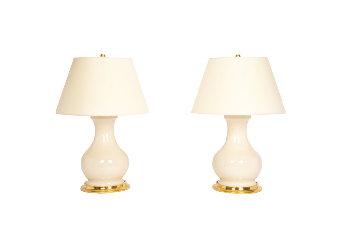 Pair of Medium Hann lamps in clear glaze with 23k gold bases, brass double socket clusters, and off white vellum paper shades, on a white background.