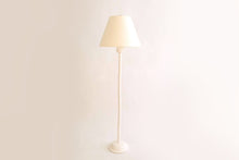 Bamboo standing lamp in glossy white lacquer, brass double socket cluster, and off white vellum paper lampshade, on a white background.