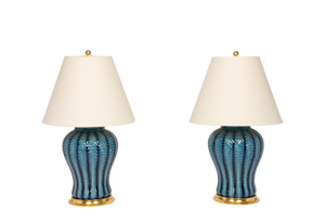 Pair of Douglas Table Lamp with Hand Slip Trailed Chevron Detail in Prussian Blue Glaze with 23k gold water gilt bases, brass double socket clusters, and off white vellum paper lamp shades, on a white background.