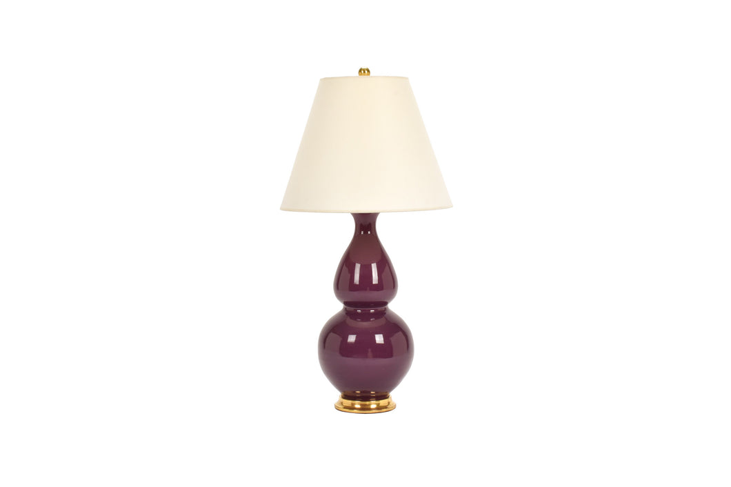 Medium Aurora lamp in purple aubergine glaze with 23k gold base, brass double socket cluster, and off white vellum paper lampshade, on a white background.