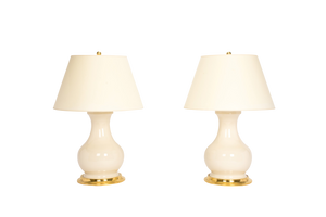 Pair of Medium Hann lamps in clear glaze with 23k gold bases, brass double socket clusters, and off white vellum paper shades, on a white background.
